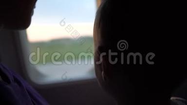 黎明时分，妈妈带着一个孩子坐在一架飞机的窗户前。